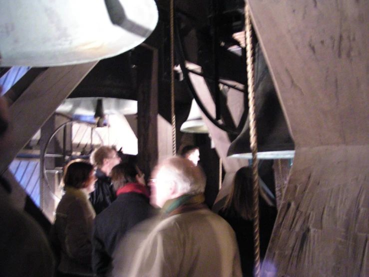 several people inside of an old - fashioned bell with ropes