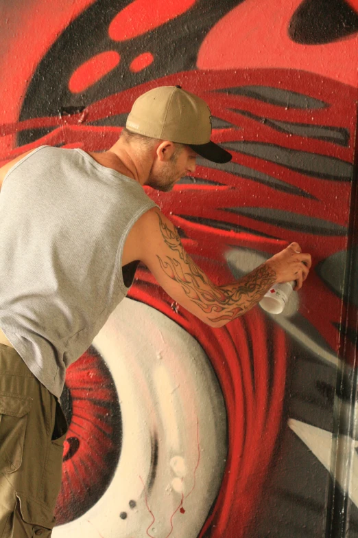 a man is spray painting the side of a wall