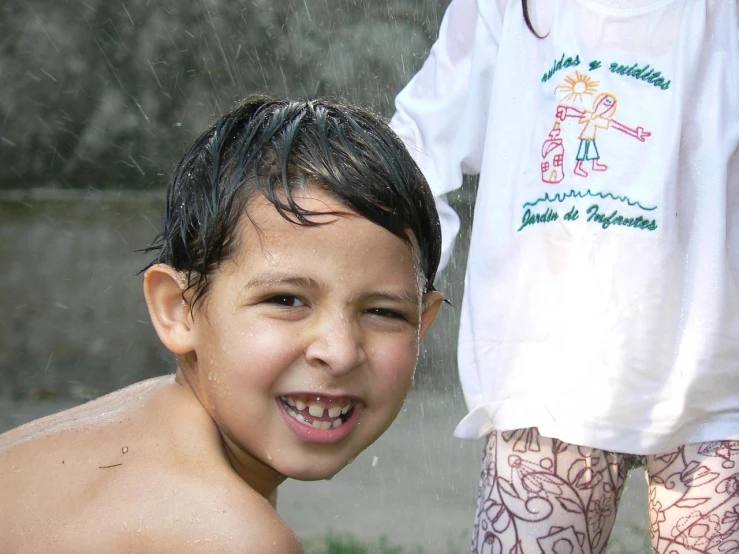 a boy has his wet hair back and smiles