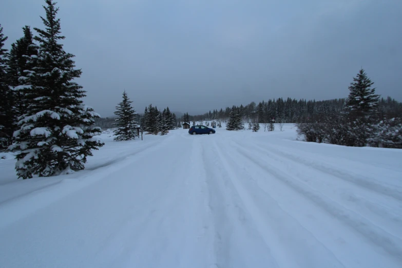 a car driving down a snow covered road