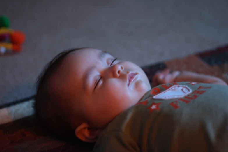 a baby has a pacifier in its mouth while laying on the floor