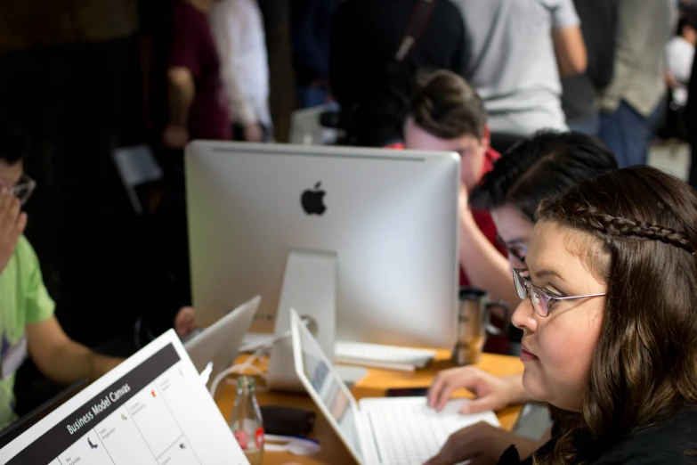 children use computers at the desk with their teacher