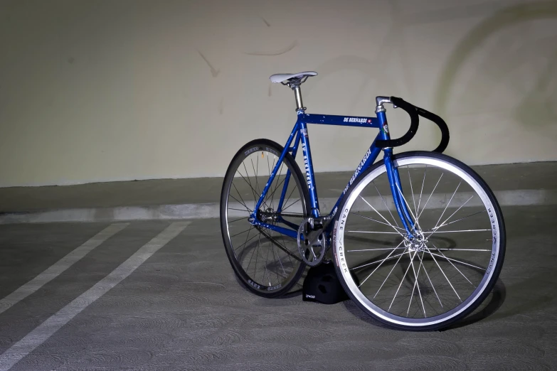 blue bike sitting in an empty parking lot