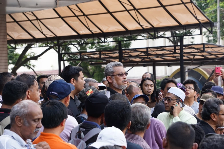 the group is standing in front of a large crowd