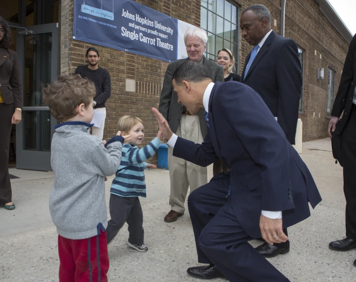 a man holds his hand up to a child in front of him