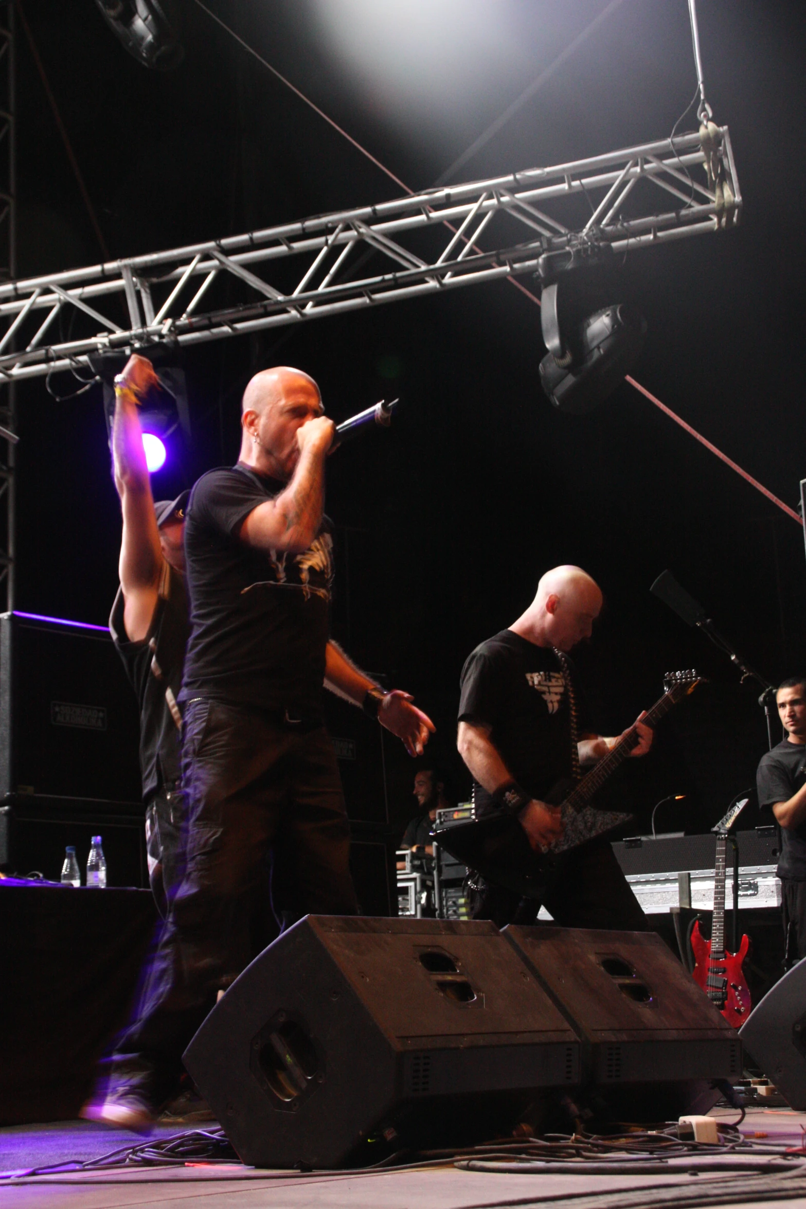 three male band performing on stage at night