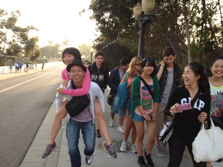 the group of friends are all smiling and walking along the side walk