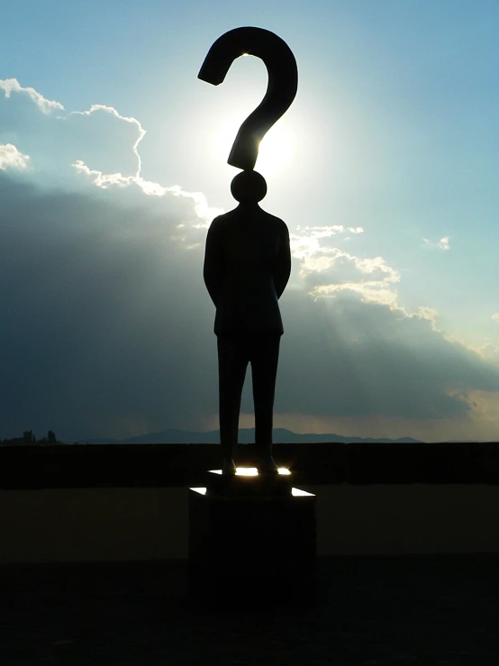 a statue that is standing up against a sun