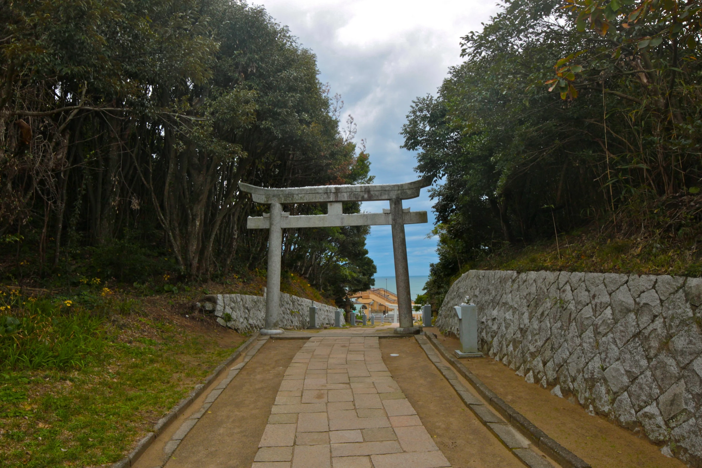 an arched passageway leading to a shrine in a forest