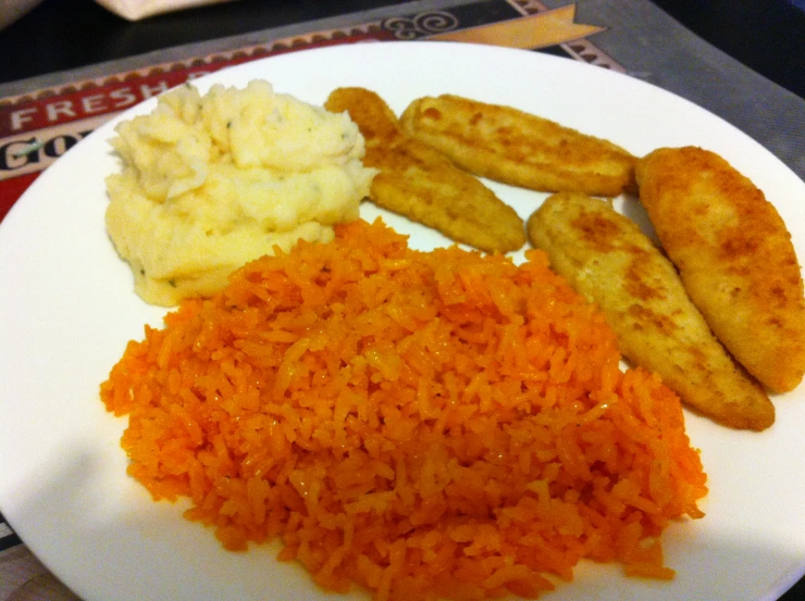 a white plate topped with rice, fried vegetables and meat