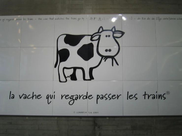 the sign has words in various languages in front of a cow