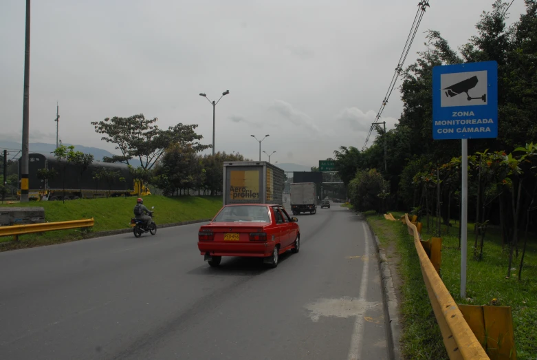 a car driving down the road past a street sign