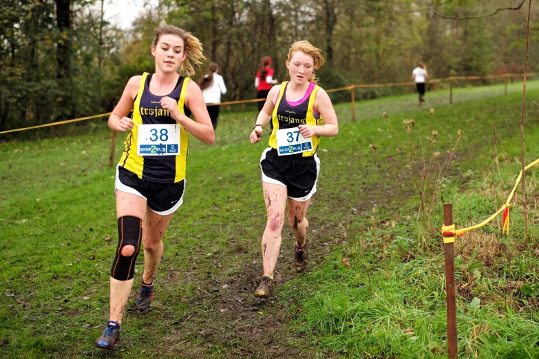 two women running on a trail in the grass