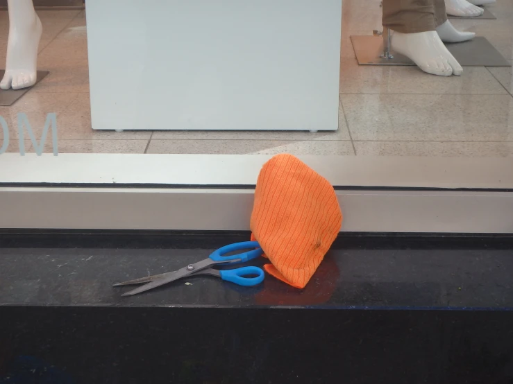 orange hat on display in the window of a shop