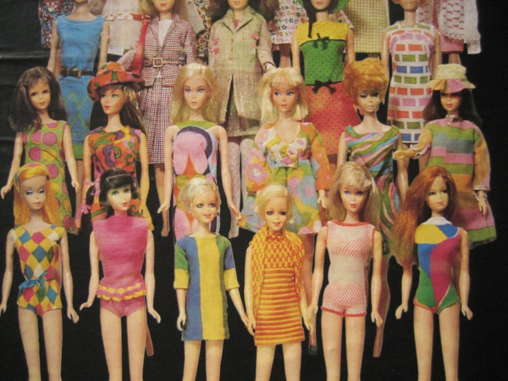 a bunch of doll dolls with some outfits on