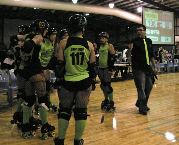 a group of people rollerblading down a wooden floor