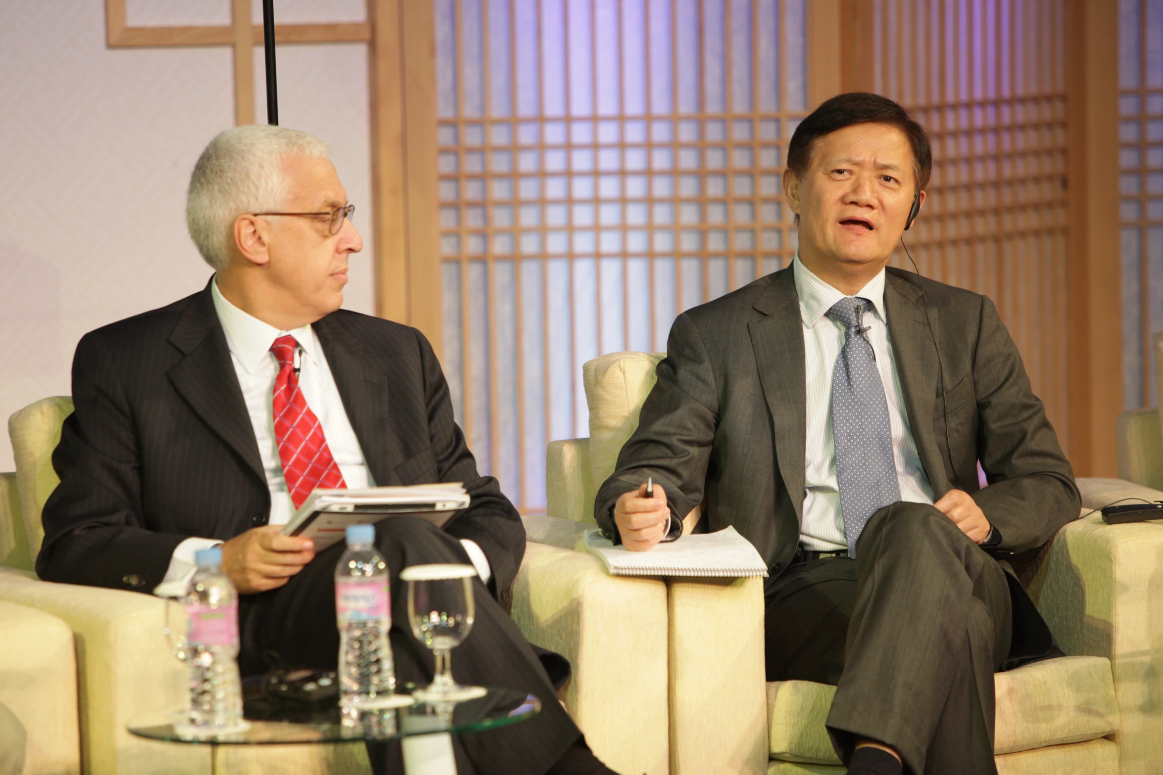 a conversation between two men who are seated on chairs