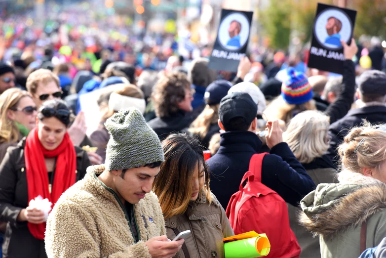 the crowd of people are looking at their cell phones