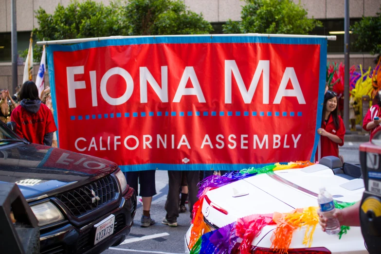 people walk in the street holding a political banner