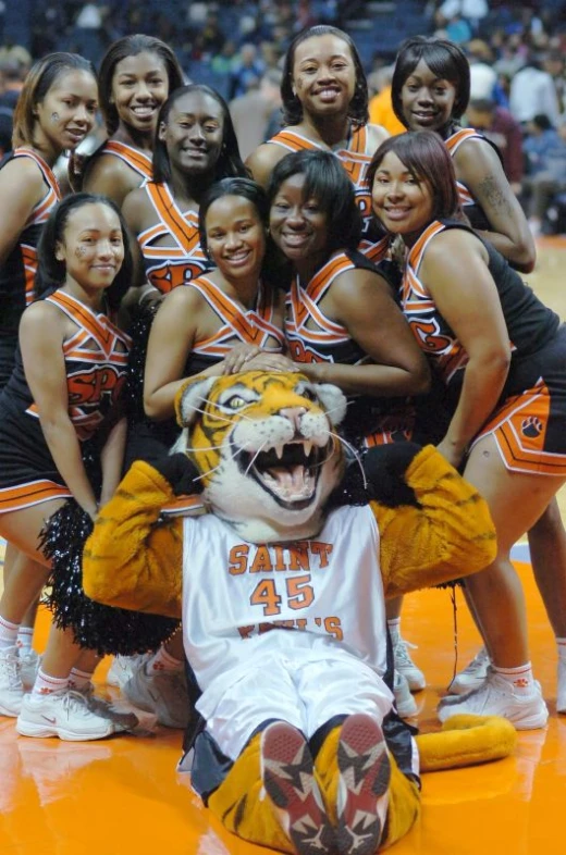 some beautiful young ladies and a cute tiger mascot