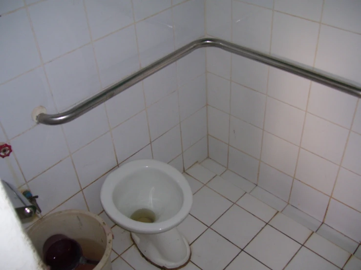 an empty toilet sits in a stall in the bathroom