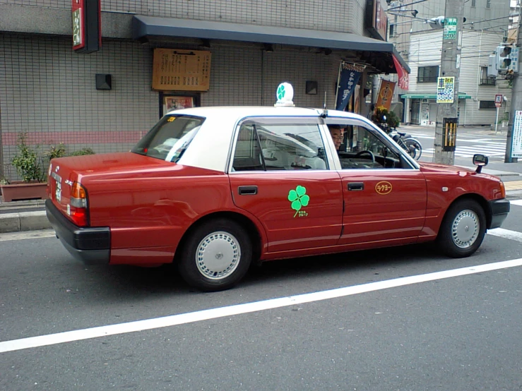 a red taxi cab parked on the side of a road