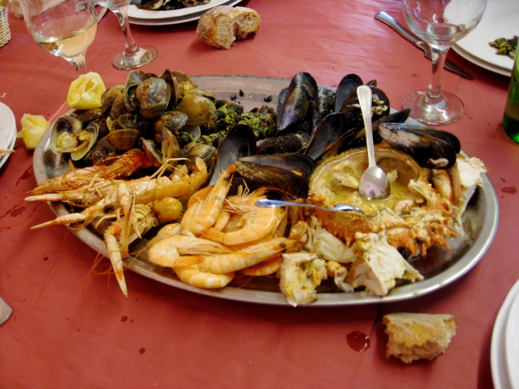 a plate full of seafood with wine on a table