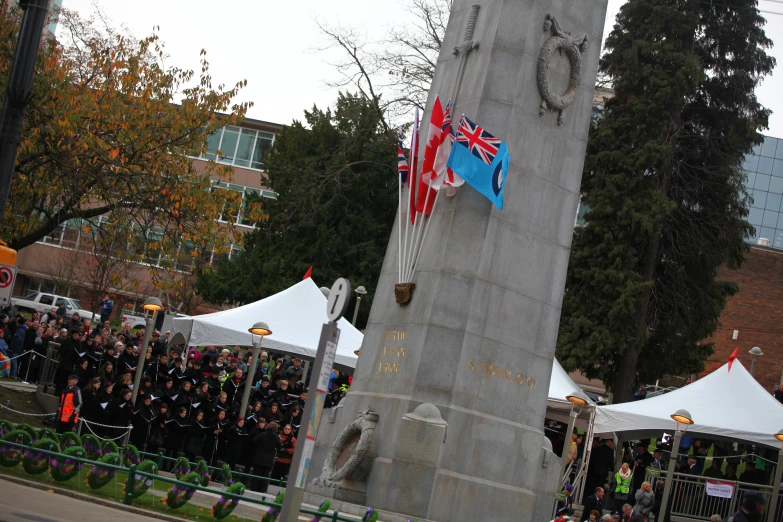 the tall statue in the middle of the street is holding flags