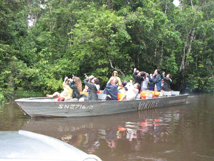 people in boat full of trash on dark water