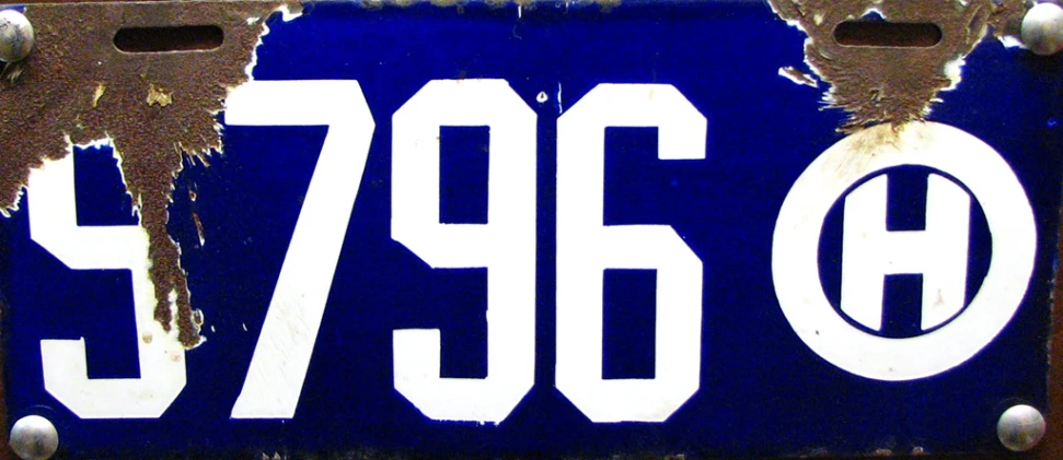 closeup of a plate with white numbers and a brown frame
