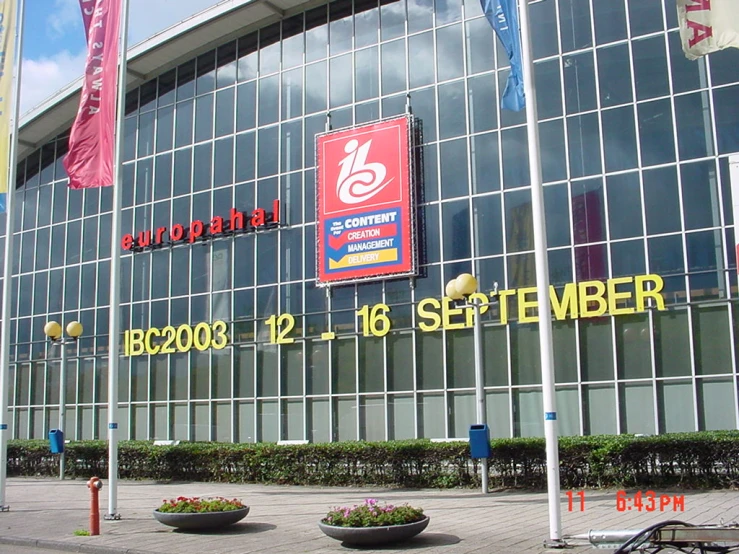 the entrance to a building with large flags flying outside