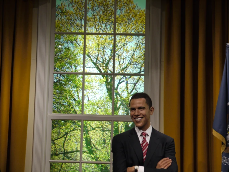 the man standing in front of a window wearing a suit