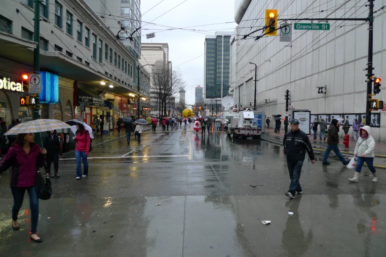 people crossing the street with umbrellas in the rain