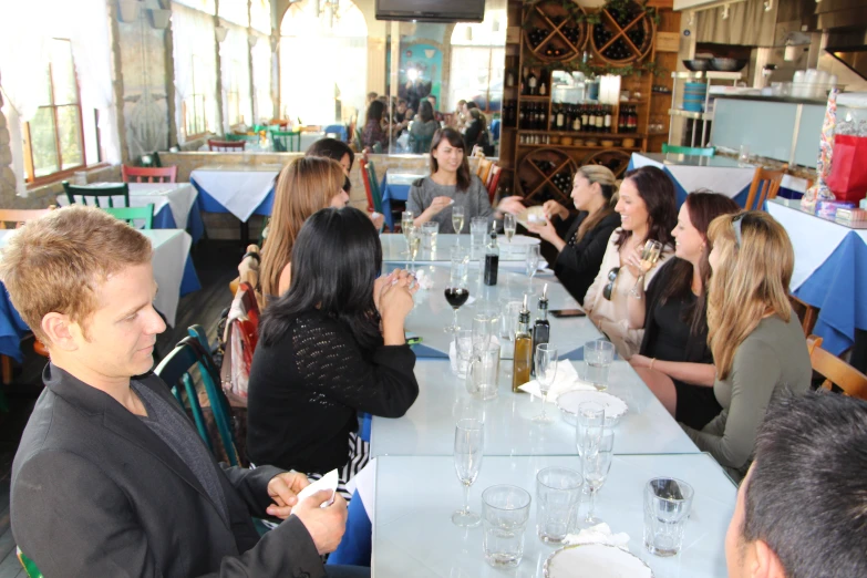 a group of people sitting around a long dining table