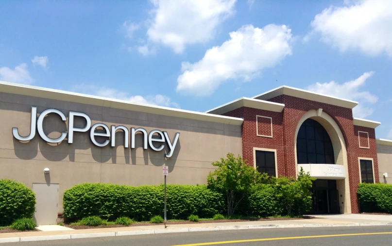 a jc penney store with some shrubs and trees outside