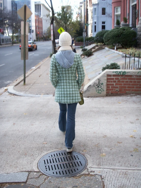 a person walking on a street with a green jacket