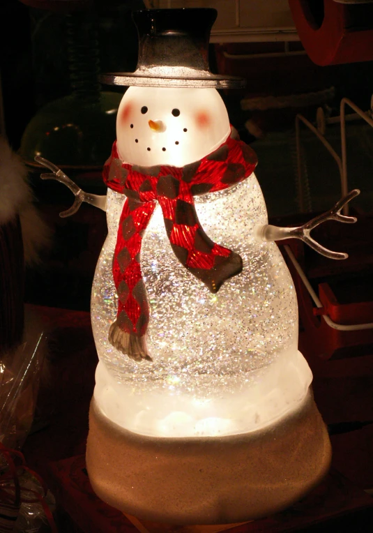 a white snowman with red and black scarf
