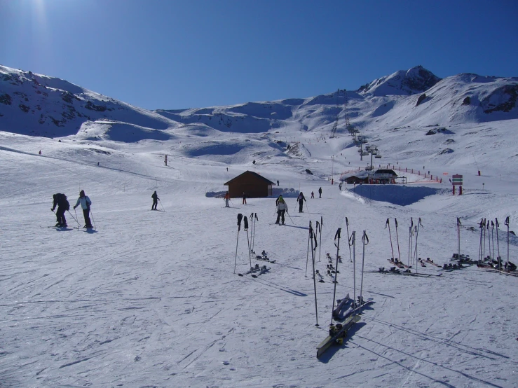 a snow covered hillside with many people standing around
