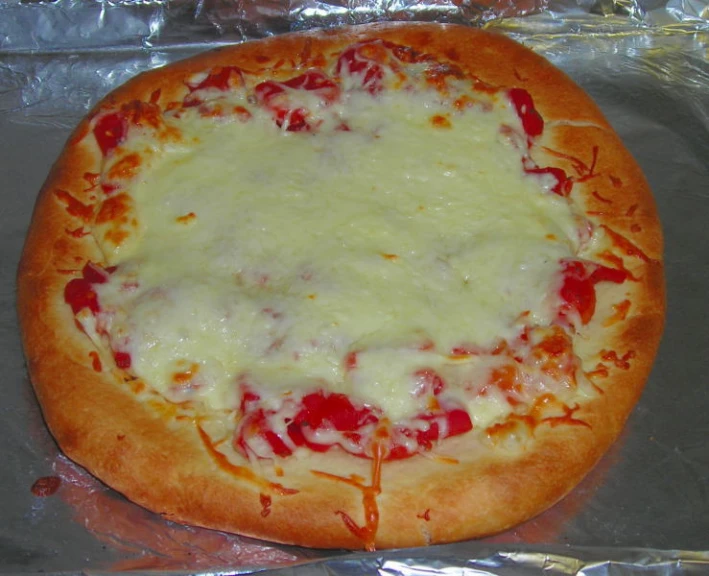 a pizza that is sitting on some tin foil