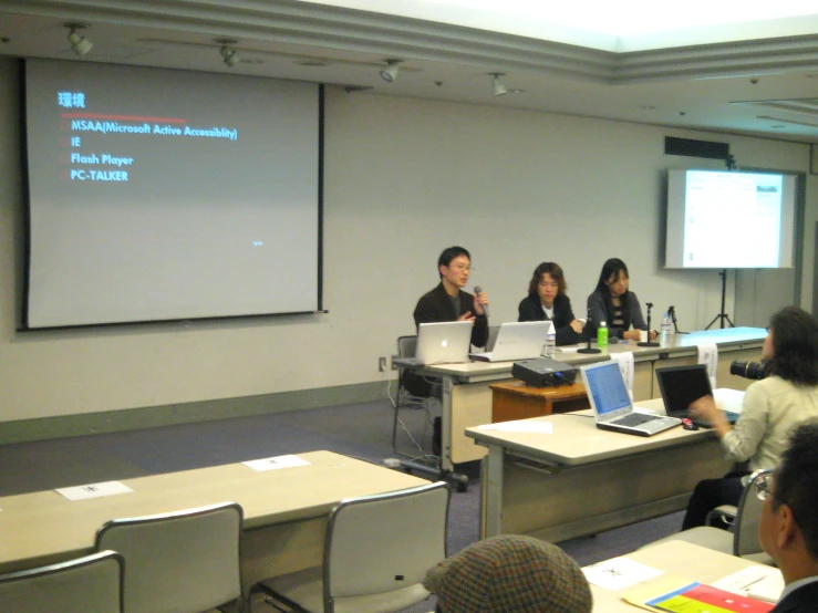 several people in a class room with laptops