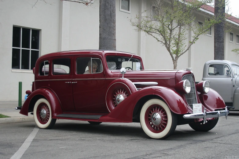 an old fashioned car is parked on the street