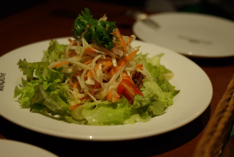 a plate with a salad in it on a table