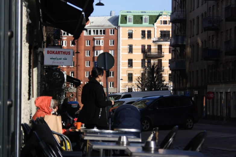 there is a person standing on the sidewalk next to some parked cars