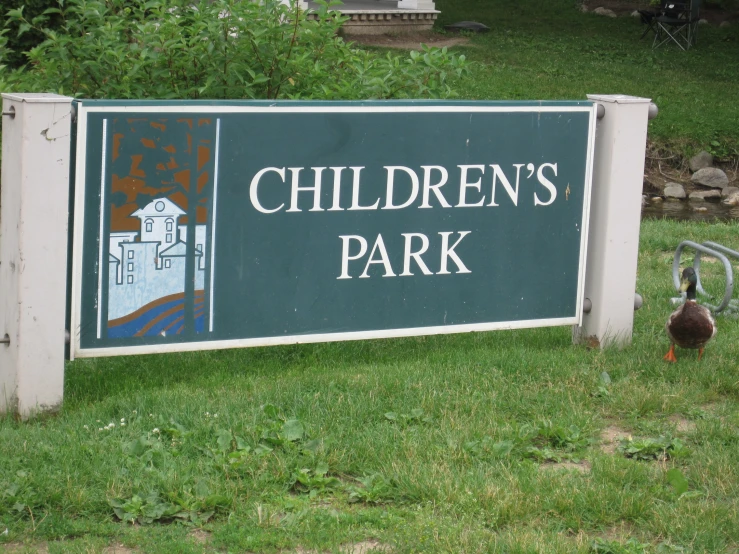 a sign advertising children's park with a duck walking away from it