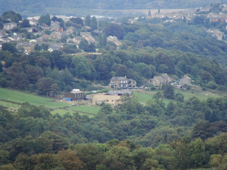 the houses on the hillside are surrounded by green trees