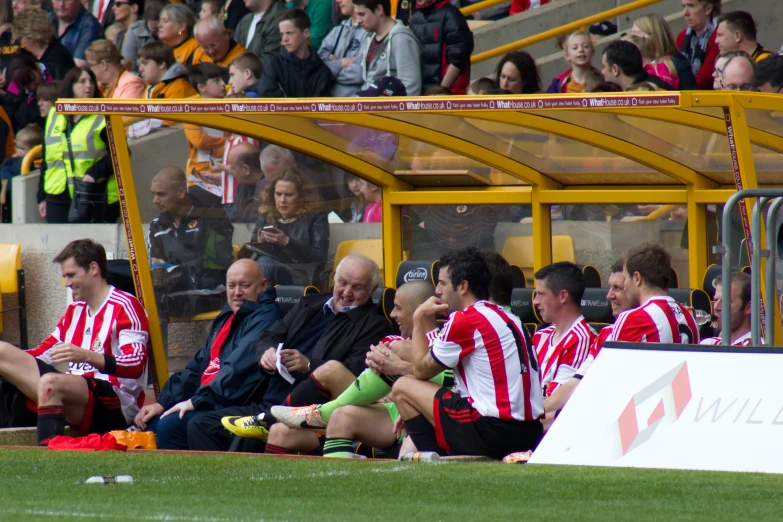 a group of men sitting on top of a soccer field