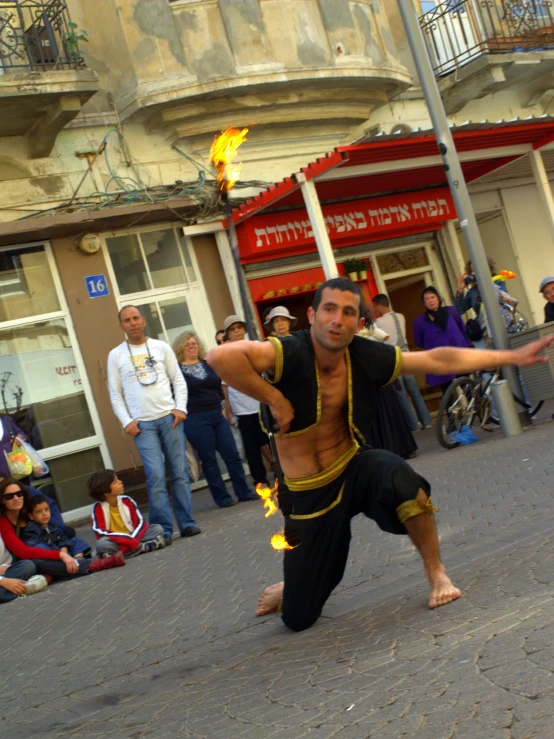 the man is doing a trick on the street with his arms outstretched