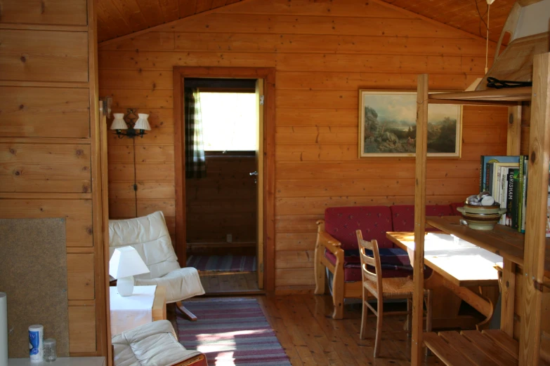 a cabin with wooden walls and tables and a rug in the corner