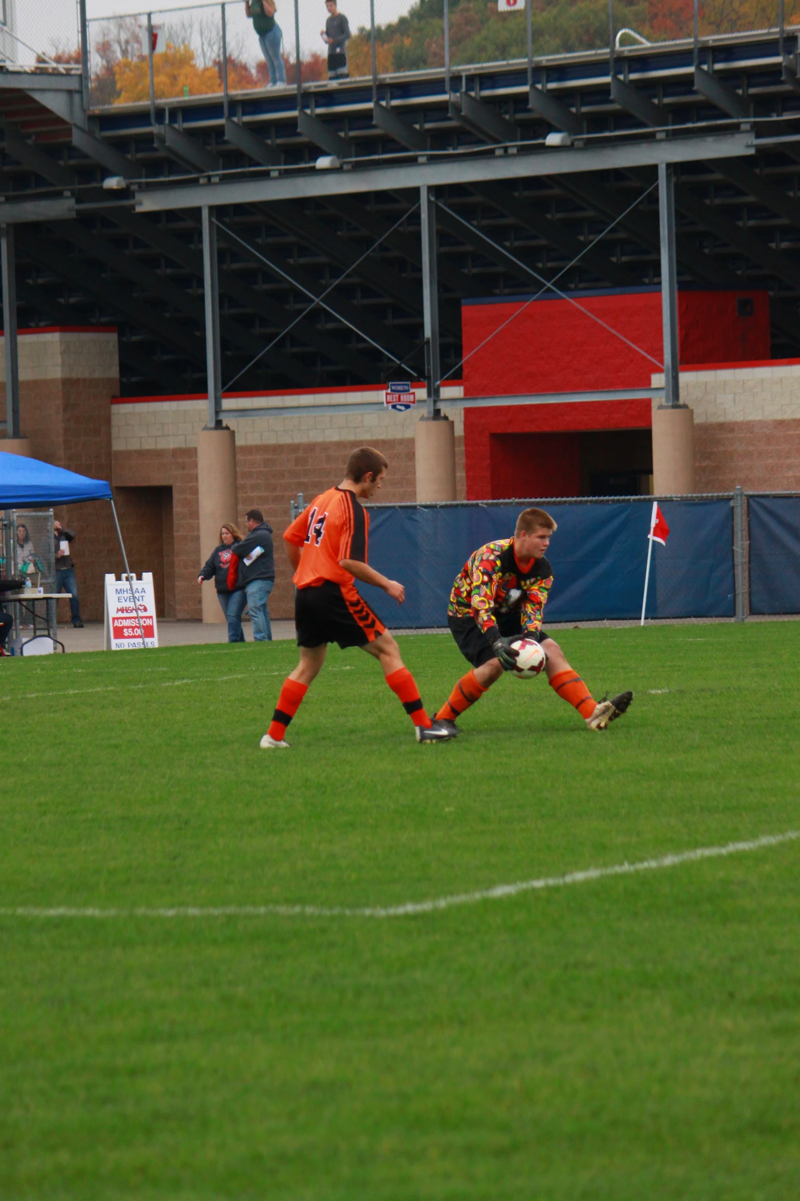 two soccer players running towards each other on a field