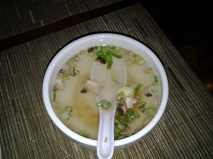 a bowl with a spoon sticking out of it sitting on top of a mat